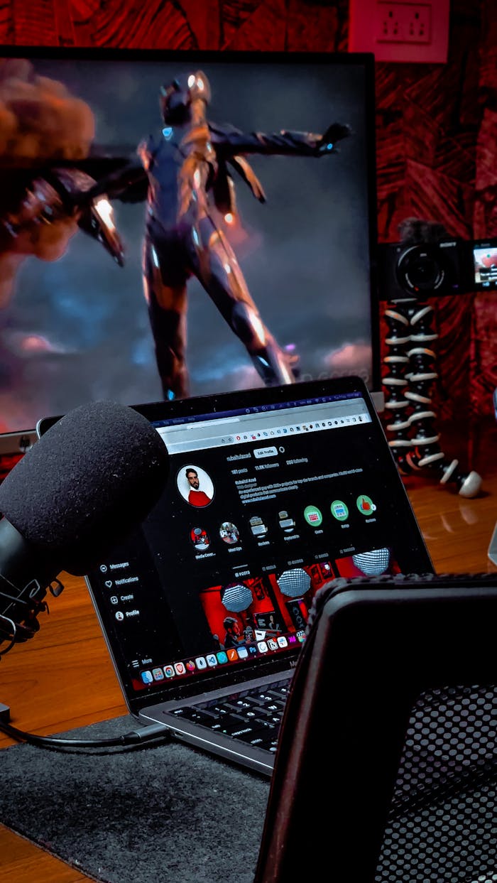 A modern home office featuring a laptop, microphone, and futuristic screen display creates a tech ambiance.