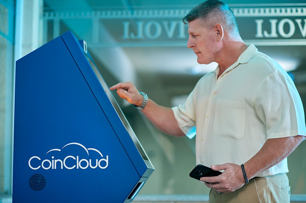 A man interacts with a cryptocurrency ATM, showcasing technology and finance innovation.